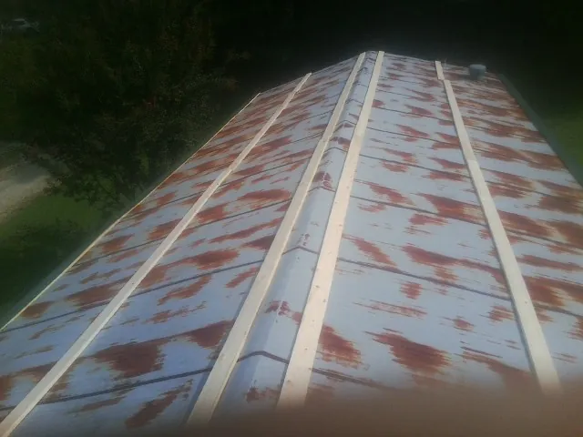 Rusted metal roof panels with new wood purlins before replacement — Storm Damage Roof Repair in Bassfield by Roofing Brothers